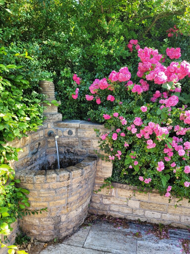 Der Bienenbrunnen in Bienenkorbform spendet kühles Wasser.